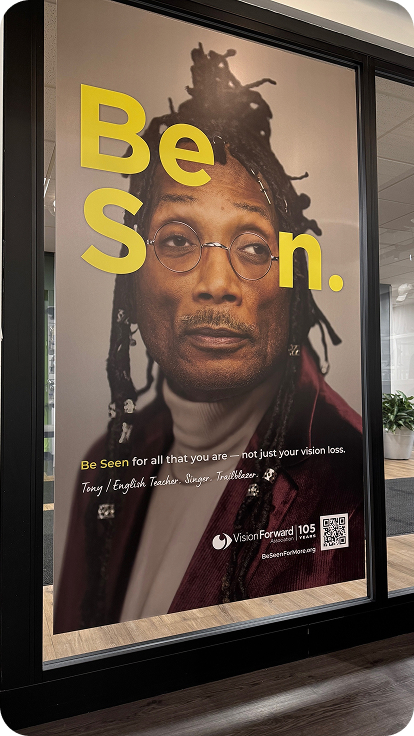 Be Seen large poster in an office setting featuring man with glasses.